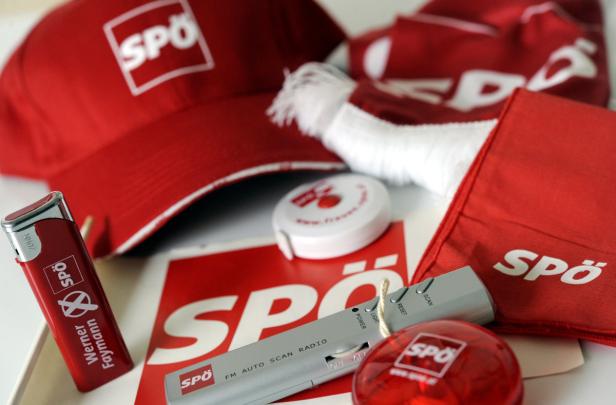 Verschiedene rote Werbeartikel der SPÖ, darunter eine Kappe und ein Feuerzeug.