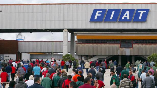 Eine Menschenmenge vor einem FIAT-Werk.