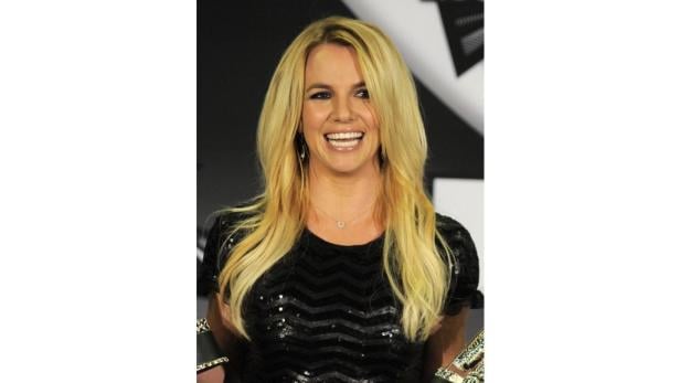 Britney Spears lächelt in einem schwarzen, paillettenbesetzten Oberteil.