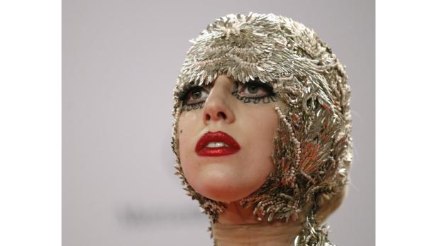 Lady Gaga trägt eine aufwendige Kopfbedeckung aus silbernen Pailletten und Perlen.