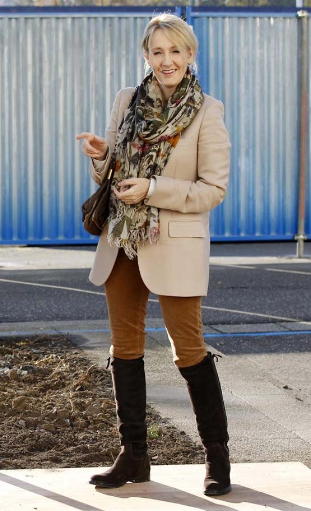 J.K. Rowling mit einem beigen Blazer, braunen Stiefeln und einem bunten Schal.