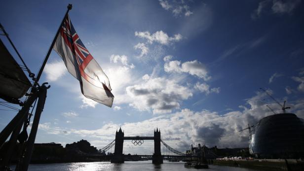 Die britische Flagge weht vor der Tower Bridge mit den olympischen Ringen in London.