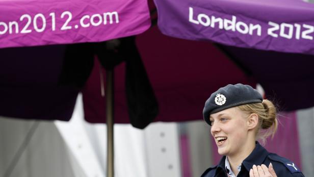 Eine lächelnde Frau in Uniform unter einem Sonnenschirm mit der Aufschrift „London 2012.com“.