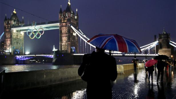 Regnerische Nacht am Tower Bridge in London mit den olympischen Ringen.