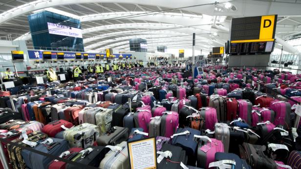 Eine große Anzahl von Gepäckstücken in einem Flughafen-Terminal.