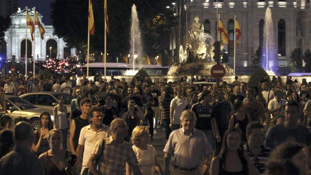 Eine Menschenmenge versammelt sich nachts am Cibeles-Brunnen in Madrid.