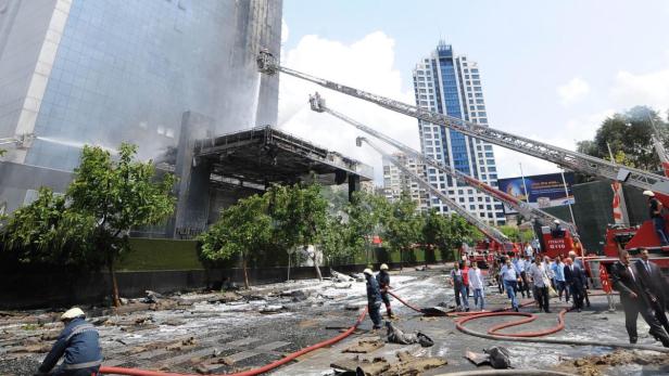 Feuerwehrleute bekämpfen einen Brand in einem Hochhaus mit Drehleitern.