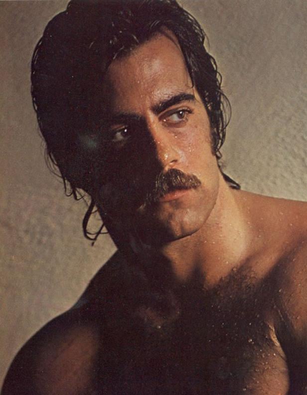 Ein Mann mit Schnurrbart und nacktem Oberkörper blickt zur Seite.