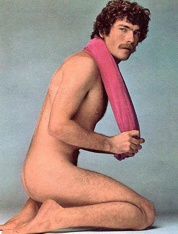 Ein Mann kniet mit einem rosa Handtuch um den Hals.