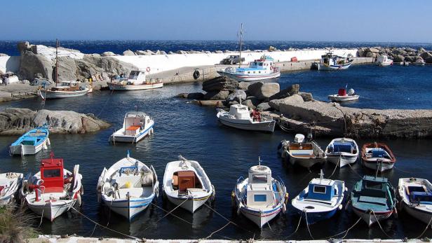 Viele kleine Boote liegen in einem Hafenbecken vor einem strahlend blauen Himmel.