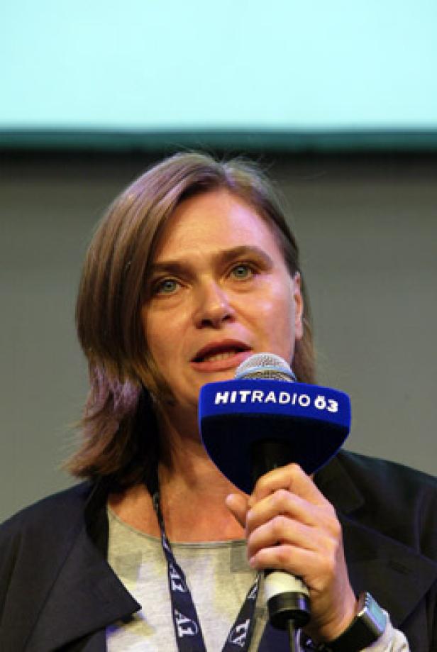 Eine Frau spricht in ein Mikrofon von Hitradio Ö3.