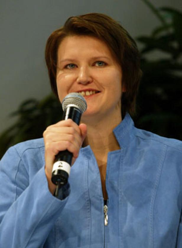 Eine Frau spricht in ein Mikrofon.