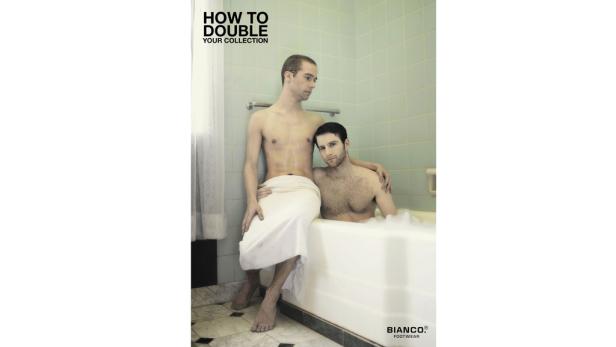 Zwei Männer posieren in einem Badezimmer, einer in der Badewanne und der andere mit einem Handtuch bekleidet.