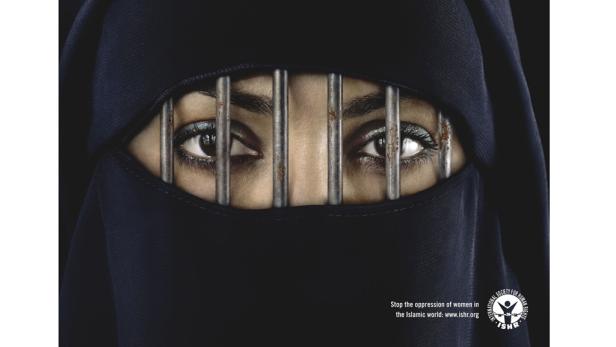 Die Augen einer Frau hinter Gittern, die einen schwarzen Niqab trägt.