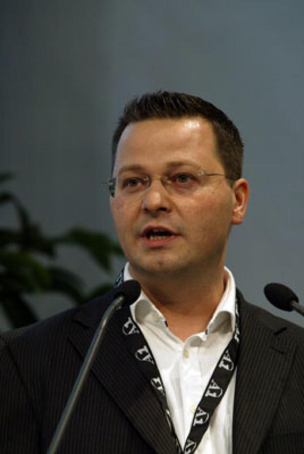 Ein Mann mit Brille spricht an einem Rednerpult.
