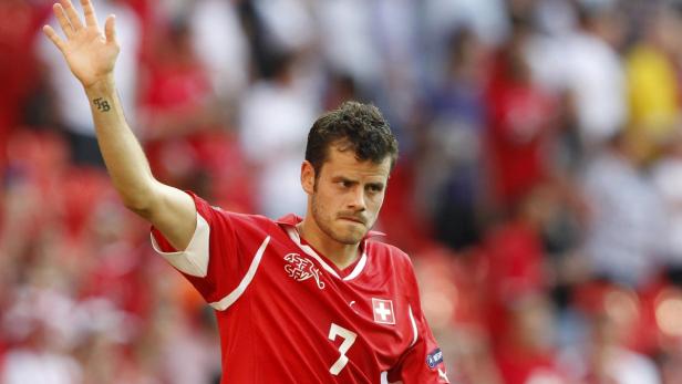 Ein Schweizer Fußballspieler mit der Nummer 7 winkt dem Publikum zu.