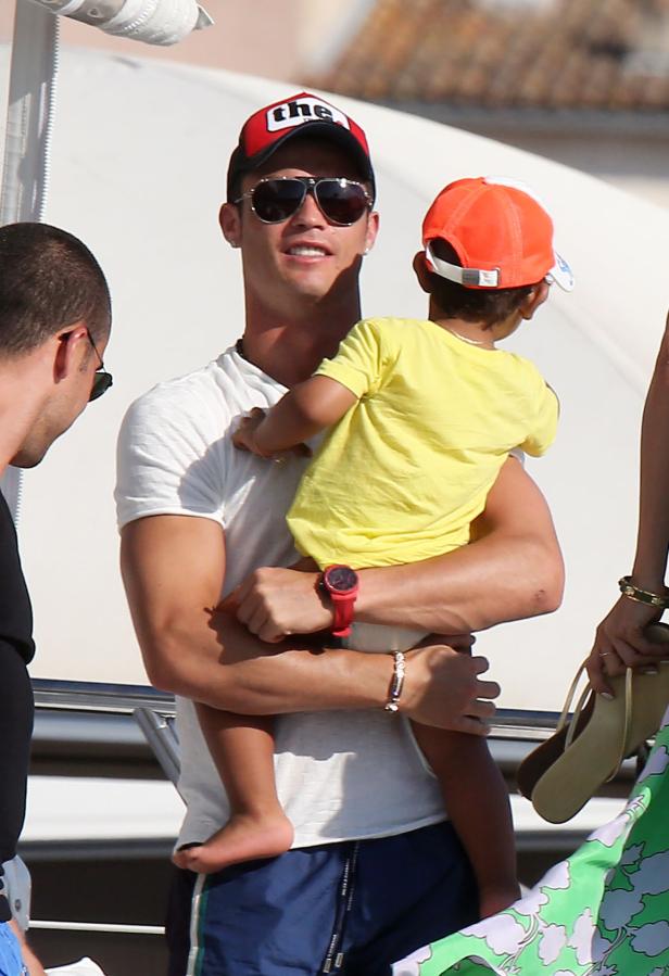 Cristiano Ronaldo trägt ein Kind auf dem Arm.