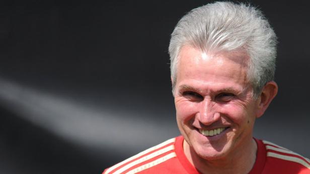 Ein lächelnder Mann mit grauen Haaren und einem roten T-Shirt mit weißen Streifen.