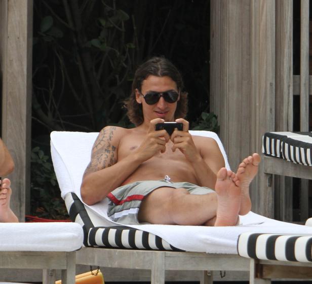 Zlatan Ibrahimović liegt auf einer Liege und benutzt sein Handy.