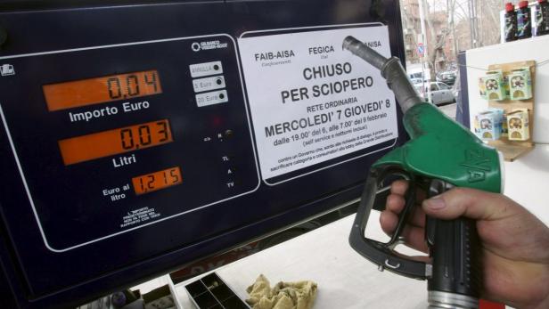 Eine Hand hält eine Zapfpistole an einer Tankstelle, die wegen Streiks geschlossen ist.