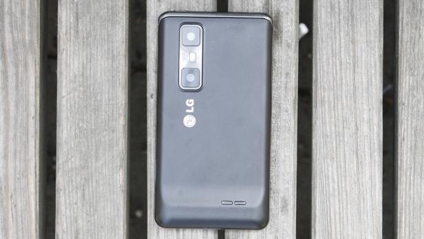 Ein graues LG-Smartphone liegt auf einer Holzbank.