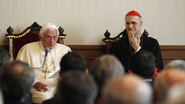 Papst Benedikt XVI. spricht vor einer Gruppe von Menschen, neben ihm ein Kardinal.