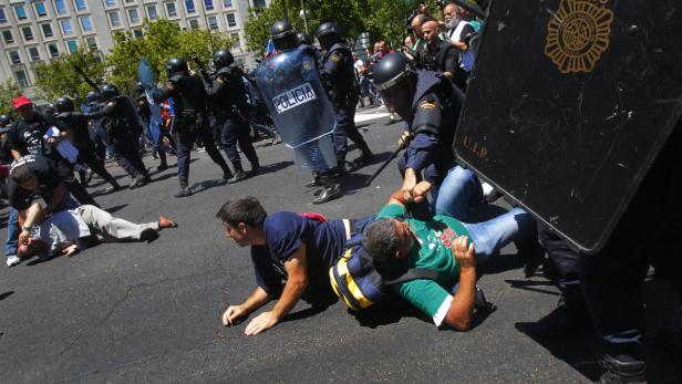 Polizisten in Kampfmontur gehen gewaltsam gegen Demonstranten vor.