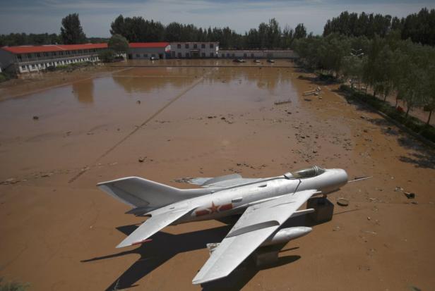 Ein chinesisches Militärflugzeug steht in einem überfluteten Gebiet.