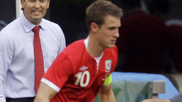 Ein walisischer Fußballspieler mit der Nummer 10 auf dem Trikot und ein Mann im Hemd mit Krawatte.