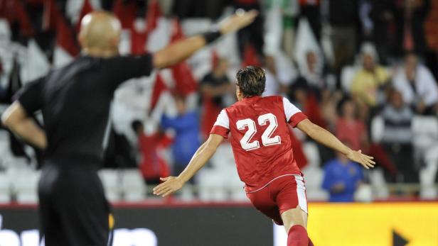 Ein Fußballspieler mit der Nummer 22 jubelt vor einer Zuschauermenge.