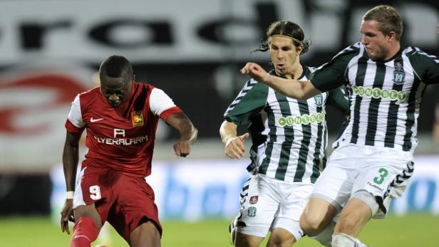 Drei Fußballspieler in Aktion während eines Spiels.