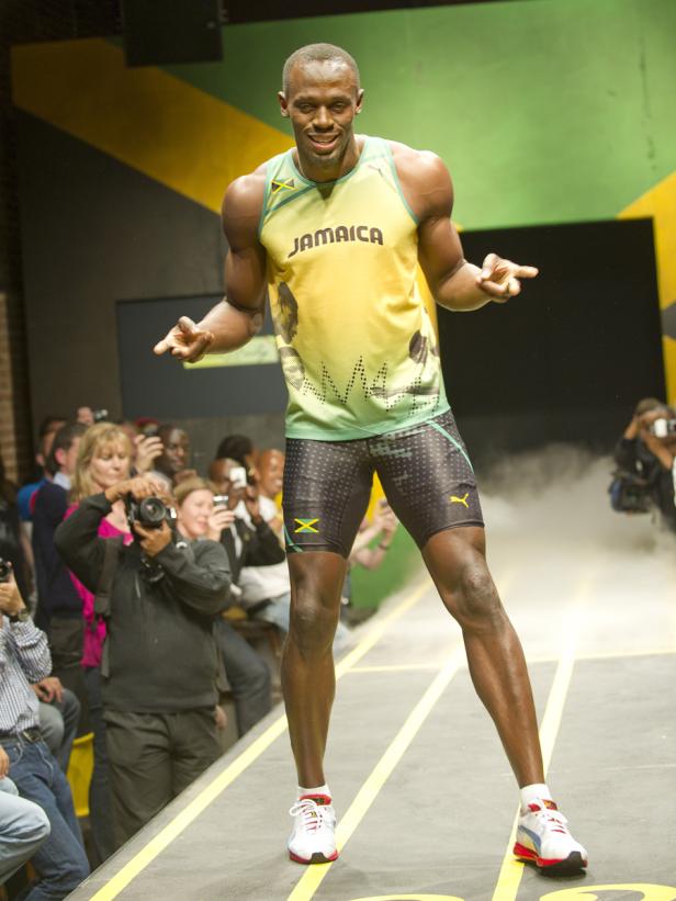 Usain Bolt posiert auf einer Bühne mit jamaikanischen Farben für Fotografen.