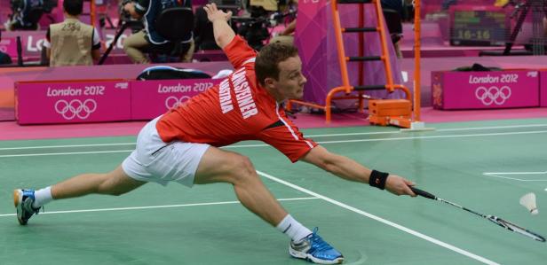 Ein Badmintonspieler aus Österreich schlägt einen Federball bei den Olympischen Spielen in London 2012.