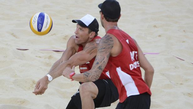 Zwei Beachvolleyballspieler bei einem Spiel im Sand.