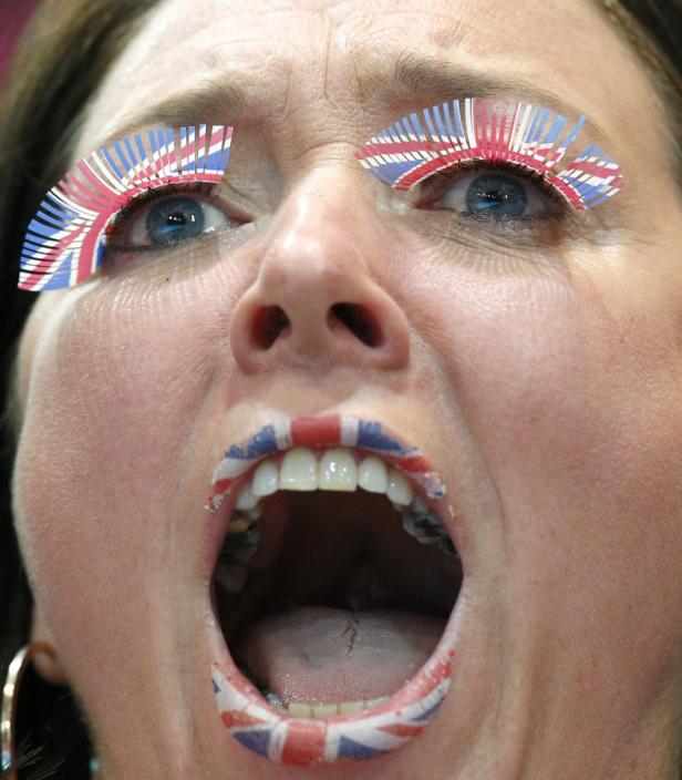 Eine Frau mit aufgemalten britischen Flaggen auf Lippen und Wimpern schreit.