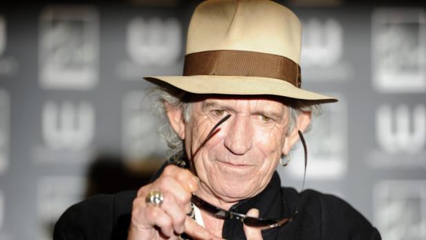 Keith Richards mit Hut und Sonnenbrille in der Hand.