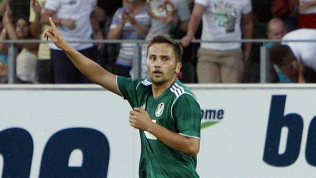 Ein Fußballspieler in Grün jubelt mit erhobenem Zeigefinger.