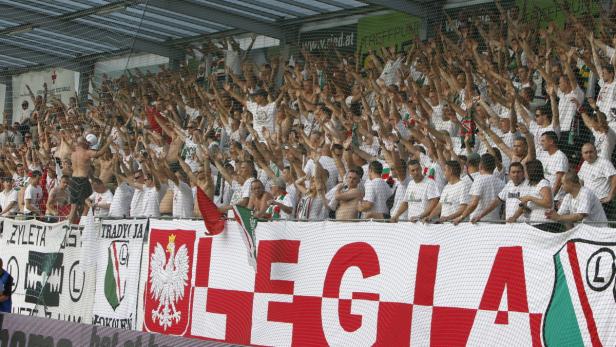 Eine große Gruppe von Fußballfans von Legia Warschau feuert ihr Team an.