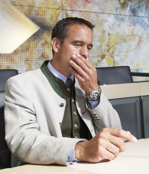 Ein Mann im Trachtenjanker sitzt nachdenklich an einem Tisch.