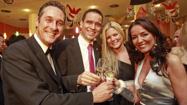 Eine Gruppe von Menschen stößt auf einer Party mit Champagnergläsern an.