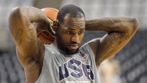 LeBron James mit einem Basketball hinter dem Kopf, während er ein graues USA-Shirt trägt.