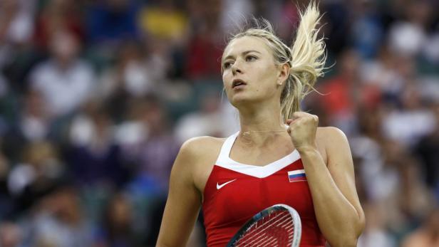 Maria Sharapova in rotem Tenniskleid mit russischer Flagge ballt die Faust.