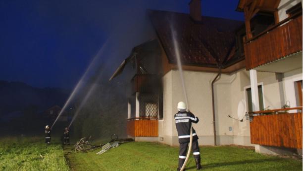 Feuerwehrleute löschen ein Haus mit Wasserwerfern.
