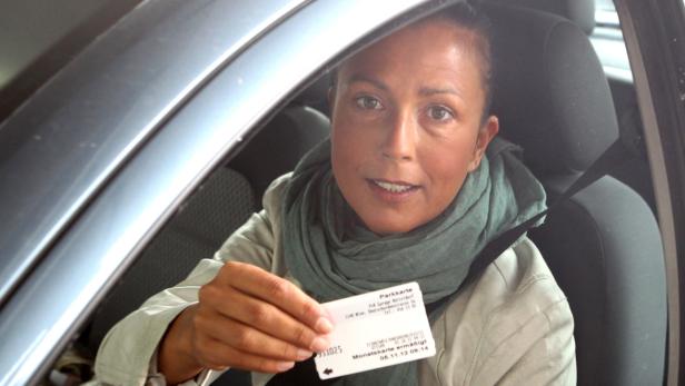 Sabine Liehr hat eine Dauerkarte Eine Frau im Auto zeigt ihre Parkkarte.