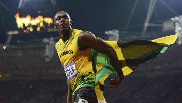 Usain Bolt feiert mit der jamaikanischen Flagge seinen Sieg.