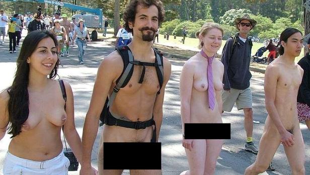 Mehrere unbekleidete Menschen nehmen an einer Veranstaltung im Freien teil.