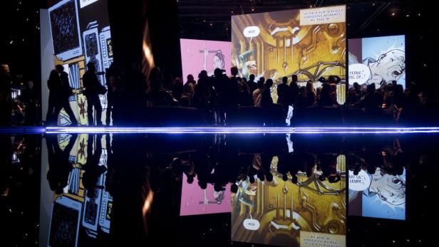 Eine Menschenmenge betrachtet Comic-Panels auf einer Ausstellung.