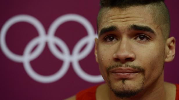 Ein weinender Mann vor dem Hintergrund der Olympischen Ringe.