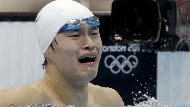 Ein Schwimmer mit Badekappe und Schwimmbrille blickt emotional auf die Olympischen Spiele in London 2012.