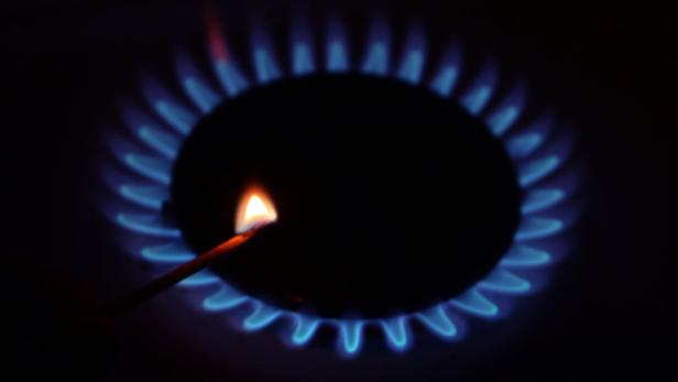 Ein Streichholz zündet eine Gasflamme an.